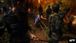Thai soldiers relay electric cable deep into the Tham Luang cave at the Khun Nam Nang Non Forest Park in Chiang Rai on June 26, 2018 during a rescue operation for a missing children's football team and their coach. 