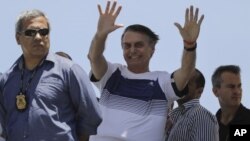 El presidente electo de Brasil, Jair Bolsonaro, saluda a sus seguidores a su llegada a una exhibición aérea del grupo de pilotos "Esquadrilha do Ceu" ("Escuadrón del cielo"), en la playa de Barra, en Río de Janeiro, Brasil, el 31 de octubre de 2018.