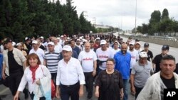 Kemal Kilicdaroglu (barisan depan, nomor dua dari kiri), pemimpin Partai Rakyat Republikan, oposisi utama Turki, berjalan dengan ribuan pendukung pada hari ke 20 aksi demo jalan kaki sepanjang 425 kilometer di Izmit, Turki, Selasa, Juli 4, 2017.