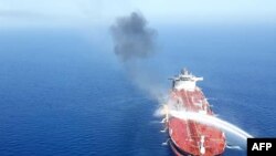 An Iranian navy boat tries to stop the fire on an oil tanker after it was attacked in the Gulf of Oman, June 13, 2019. 