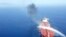 An Iranian navy boat tries to stop the fire on an oil tanker after it was attacked in the Gulf of Oman, June 13, 2019. 