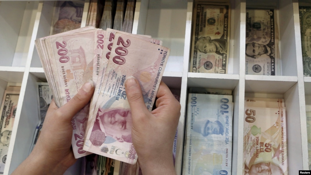 FILE - A money changer counts Turkish lira bills at an currency exchange office in central Istanbul, Turkey, Aug. 21, 2015.