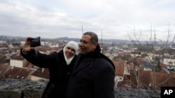 In this photo taken Dec. 16, 2016, Abd Alwahab Alahamad and his wife Iman Mshanati take a selfie atop the castle overlooking the town of Gray, eastern France. 
