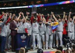 Washington Nationals manager Dave Martinez and his team hoist the Commissioners Trophy after defeating the Houston Astros in game seven of the 2019 World Series in Houston, Texas, October 30, 2019.