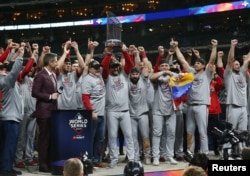 Washington Nationals manager Dave Martinez and his team hoist the Commissioners Trophy after defeating the Houston Astros in game seven of the 2019 World Series in Houston, Texas, October 30, 2019.