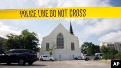 FILE - Police tape surrounds the parking lot behind the AME Emanuel Church as FBI forensic experts work the crime scene, June 19, 2015.