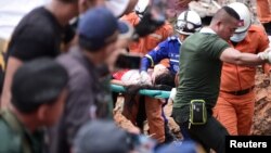 ພວກ​ກູ້​ໄພ ພາ​ກັນ​ຫາມ​ຜູ້​ລອດ​ຊີ​ວິດ​ມາ​ໄດ້ ຈາກຊາກ​ຫັກ​ພັງ​ຂອງ​ຕຶກ ທີ່​ເມືອງ Sihanoukville, ​ກຳ​ປູ​ເຈຍ, 22 ມິ​ຖຸ​ນາ 2019. 