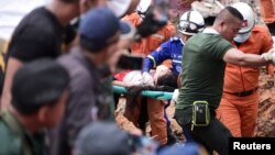 Tim penyelamat mengusung pekerja yang terluka dari gedung yang runtuh di Sihanoukville, Kamboja, 22 Juni 2019 (foto: Reuters/Stringer)