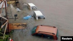 Mobil terendam akibat topan Halong di Kochi, Jepang barat di foto yang diambil oleh Kyodo 10 Agustus 2014. Topanm Halong menewaskan satu orang di Jepang Minggu, 10 Agustus 2014 dan 33 lainnya cedera.