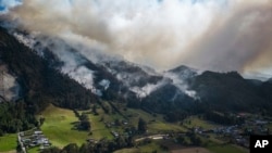 El humo se eleva de un incendio que arde en las laderas de las montañas que rodean Nemocón, al norte de Bogotá, Colombia, el martes 23 de enero de 2024. 