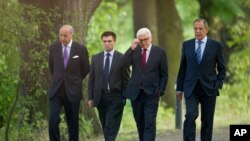 Foreign Ministers of France Laurent Fabius, Ukraine Pavlo Klimkin, Germany Frank-Walter Steinmeier and Russia Sergey Lavrov, from left, go for a walk before a meeting at the Guesthouse of Foreign Ministry Villa Borsig in Berlin, Sunday, Aug. 17, 2014.