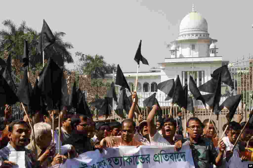 Bangladeshi Hindus wave black flags as they march through a street to protest against alleged attacks by Jamaat-e-Islami activists in Dhaka, Bangladesh, March 2, 2013.