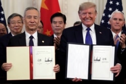 President Donald Trump signs a trade agreement with Chinese Vice Premier Liu He, in the East Room of the White House, Jan. 15, 2020, in Washington.