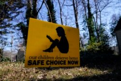 Sebuah banner bertuliskan: "Anak-anak kita pantas mendapatkan pilihan (pendidikan) yang aman saat ini" di Decatur, Georgia, AS.