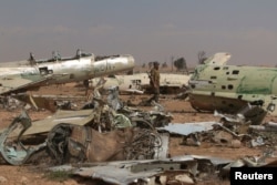 A Syrian Democratic Forces (SDF) fighter walks near destroyed airplane parts inside Tabqa military airport after taking control of it from Islamic State fighters, west of Raqqa city, Syria April 9, 2017.