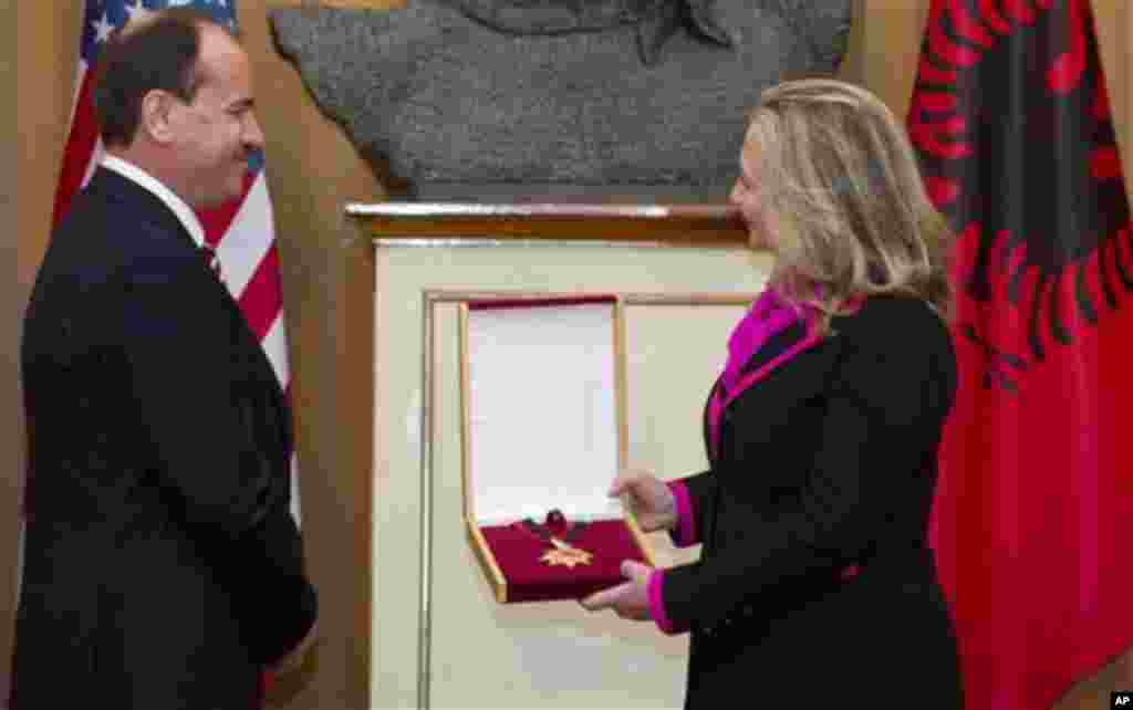 Albanian President Bujar Nishani presents US Secretary of State Hillary Clinton with the Order of the National Flag following meetings at the Palace of the Brigades in Tirana, Albania, Thursday, Nov. 1, 2012. Hillary Clinton arrived in EU-hopeful Albania 