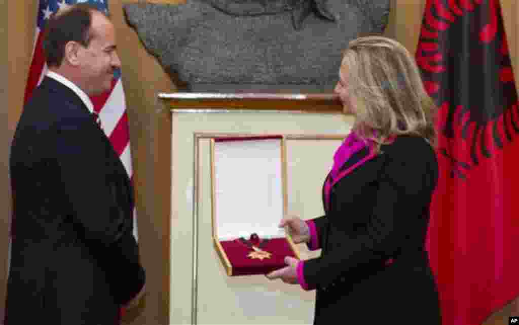 Albanian President Bujar Nishani presents US Secretary of State Hillary Clinton with the Order of the National Flag following meetings at the Palace of the Brigades in Tirana, Albania, Thursday, Nov. 1, 2012. Hillary Clinton arrived in EU-hopeful Albania