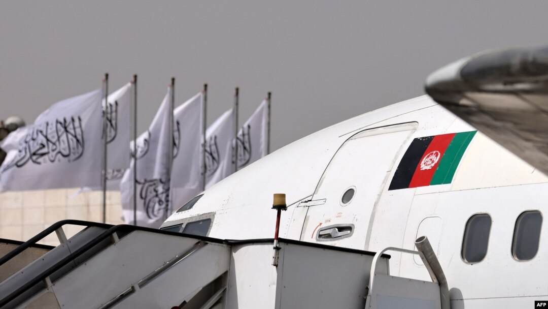 Sobiq hukumat bayrog'i aks etgan samolyot Tolibon bayroqlari o'rnatilgan aeroportda. Kobul, 11-sentabr, 2021. 