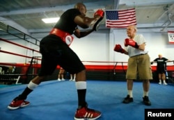 Parkinson's patient Jim Coppula works out in the ring with boxing coach Justice Smith (L) during his Rock Steady Boxing session in Costa Mesa, California September 16, 2013.