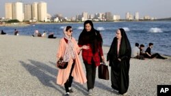 2019年7月6德黑兰波斯湾烈士湖岸边行走的伊朗妇女。