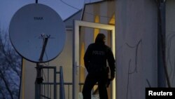 Seorang polisi Jerman berdiri di depan pintu kaca yang pecah di Masjid Bilal, Frankfurt, negara bagian Hesse, 1 Februari 2017. (Foto: dok).