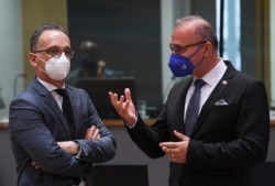 German Foreign minister Heiko Maas (L) talks with Crotian Foreign minister Gordan Grlic Radman (R) during a Foreign Affairs Council meeting at the EU headquarters in Brussels on July 12, 2021.