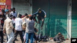 Activists of the Bangladesh Nationalist Party attack security officers during a protest in Dhaka, Bangladesh, Oct. 28, 2023. Police in Bangladesh's capital fired tear gas to disperse supporters of the main opposition party who threw stones at security officials.