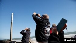 资料照片：人们在南卡罗莱纳州瑟夫赛德海滩用手机拍摄疑似中国间谍气球。(2023年2月4日)
