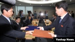 14일 개성공단 종합지원센터에서 열린 제7차 개성공단 남북당국실무회담이 타결된 후, 남북한 대표단이 합의서를 교환하고 있다. 