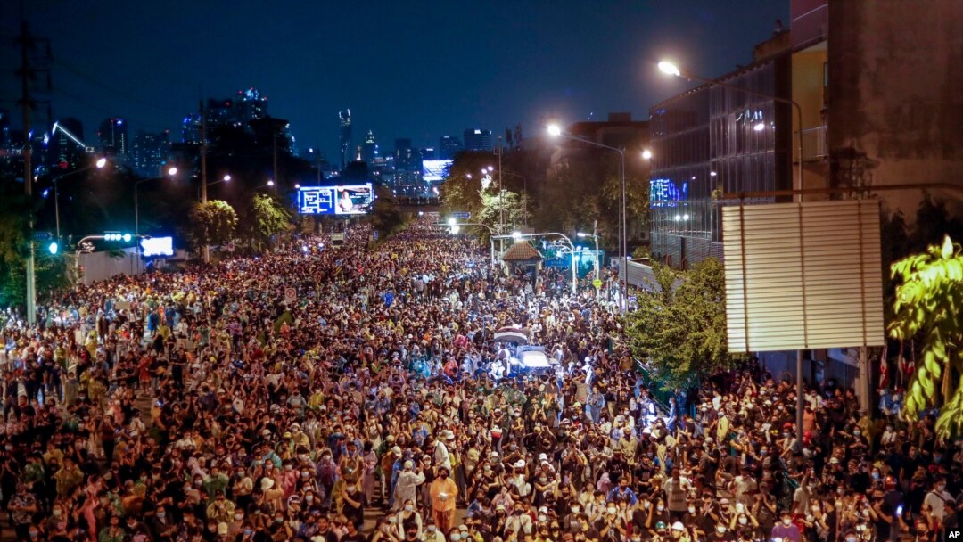Pro-democracy activists march by Government House, the prime minister's offices, during a protest in Bangkok, Thailand, Oct. 21, 2020.