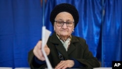 A woman casts her vote in the country's presidential elections, in Bucharest, Romania, Nov. 24, 2024.