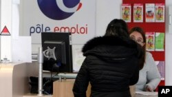 A job seeker speaks to a clerk at an Employment Center in Marseille, southern France, Feb. 24, 2015. Record-high unemployment started dragging French President Francois Hollande's popularity down just a few months after his election in 2012.