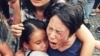 Bà Hoàng Mỹ Uyên ôm con gái trong vụ xô xát giữa lực lượng an ninh Việt Nam với người biểu tình hôm 8/5 ở Sài Gòn. 