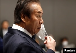 Anggota Dewan Eksekutif Komite Penyelenggara Olimpiade dan Paralimpiade Tokyo (Tokyo 2020) Haruyuki Takahashi mengenakan masker di tengah wabah COVID-19, selama Rapat Dewan Eksekutif Tokyo 2020 di Tokyo, Jepang 30 Maret , 2020. (REUTERS/Issei Kato/Pool)