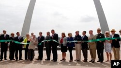 Susan Saarinen, daughter of Gateway Arch architect Eero Saarinen, cuts the ribbon dedicating the renovation of the Gateway Arch National Park, July 3, 2018, in St. Louis. The $380 million project has transformed the entrance to the Arch as well as its museum and the grounds surrounding the monument.