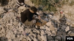 Mosul resident Ahmad Saeed collects the smashed art pieces of his grandfather Abdulla Husain who was killed during the battle for Mosul July last year, January 2018. (K Omar/VOA)