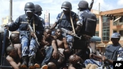Rioters sit on the back of a police truck after their arrest in the capital city Kampala, Uganda after riots broke out, April 29, 2011
