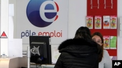 A job seeker speaks to a clerk at an Employment Center in Marseille, southern France, Feb. 24, 2015. Record-high unemployment started dragging French President Francois Hollande's popularity down just a few months after his election in 2012.