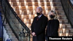 El presidente de Estados Unidos, Joe Biden, y la primera dama, Jill Biden, guardan un minuto de silencio en honor a las víctimas de la pandemia, en los jardines de la Casa Blanca, el 22 de febrero de 2021.