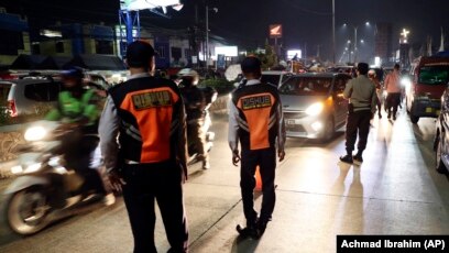 Para petugas Dishub dan polisi menjaga pos pemeriksaan di Cibitung, Bekasi, Jawa Barat, saat penerapan larangan mudik nasional untuk mencegah penyebaran pandemi COVID-19, Minggu, 9 Mei 2021. (Foto: Achmad Ibrahim/AP)