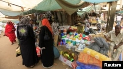 Women wait to buy things for Ramadan at a central food market in Khartoum, Sudan, July 18, 2012. 