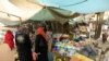 FILE- Women wait to buy things for Ramadan at a central food market in Khartoum, Sudan, July 18, 2012. Sudan's currency fell close to its historical low against the dollar as demand for imported food surged before the holy Muslim month of Ramadan, driving up pr