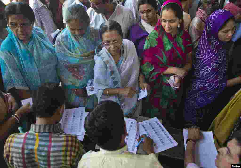 Voters get their names checked at a polling station during the final phase of the general election in Varanasi in the northern Indian state of Uttar Pradesh, May 12, 2014.