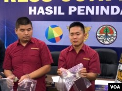 Dua tersangka PF (kiri) dan XY (kanan) WN China yang melakukan percobaan penyelundupan sisik trenggiling di Bandara Internasional Kualanamu, Deli Serdang, Sumatera Utara. Senin (29/4). (VOA/Anugrah Andriansyah)