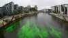 A section of the River Spree next to the Reichstag building, seat of the German lower house of Parliament Bundestag, is colored green by activists from the &quot;Extinction Rebellion&quot; to protest the government&#39;s coal policies in Berlin.