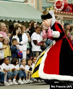 An actor dressed as the "Queen of Hearts" from "Alice in Wonderland" entertains children during "Walt Disney's Parade of Dreams" at Disneyland in California, 2005. (AP/Ric Francis)