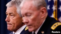 U.S. Defense Secretary Chuck Hagel (L) listens as Chairman of the Joint Chief of Staff General Martin Dempsey (R) speaks during a briefing on the Defense Department's FY2014 budget at the Pentagon, Apr. 10, 2013. 