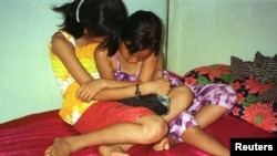 Hai bé gái người Việt 8 tuổi và 10 tuổi ngồi trên một chiếc giường trong một nhà thổ ở tại làng Svay Pak, gần Phnom Penh, Campuchia. (Ảnh tư liệu).