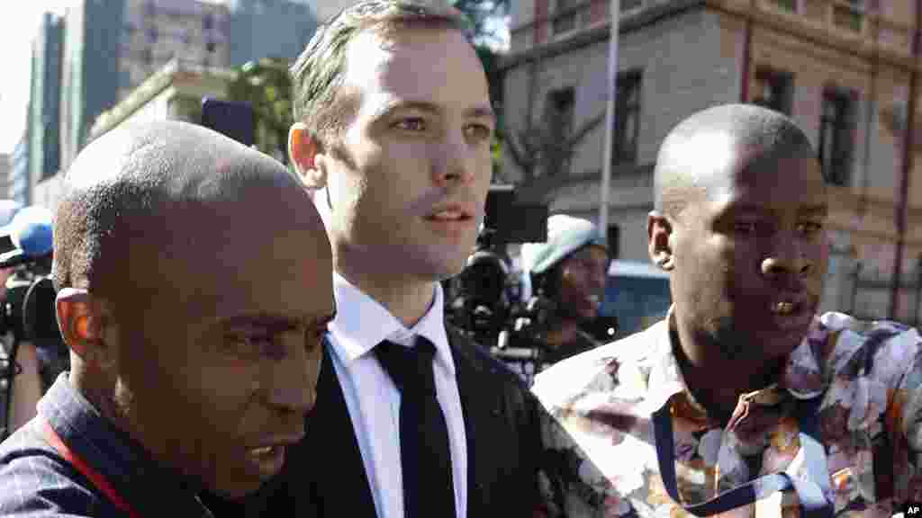 Oscar Pistorius, escorté par un homme non identifié après l'audience à Pretoria, Afrique du Sud, le 18 avril, 2016.