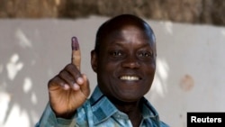 FILE - PAIGC party's candidate Jose Mario Vaz shows his inked finger after voting in Bissau, Guinea-Bissau, April 13, 2014.